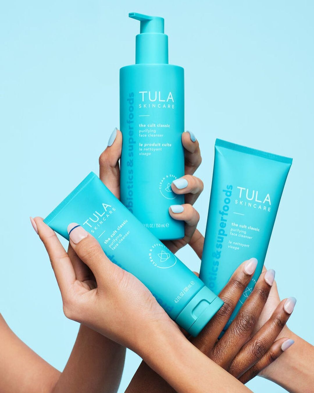 TULA Skincare products featuring the cult classic purifying face cleanser are displayed with three different skin tones.
