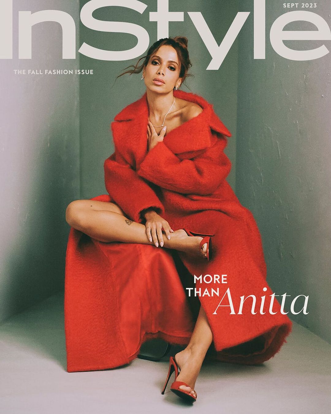 InStyle cover featuring a woman in a red coat and red high heels sitting cross-legged against a gray backdrop. The magazine's logo is at the top.