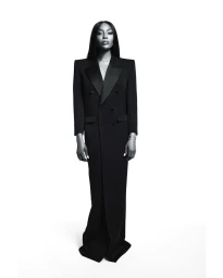 Naomi Campbell wearing a structured black double-breasted coat against a white background in a portrait by Joseph Degbadjo.