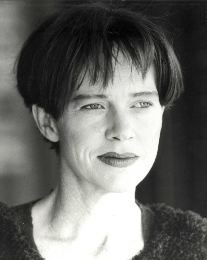 Black and white portrait of an adult female with short dark hair, wearing a textured top, looking off to the side with a neutral expression.