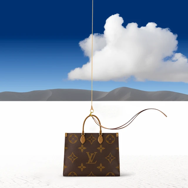 Luxury Louis Vuitton handbag suspended by a string in a surreal landscape with a blue sky and clouds behind it. Fashion accessory.