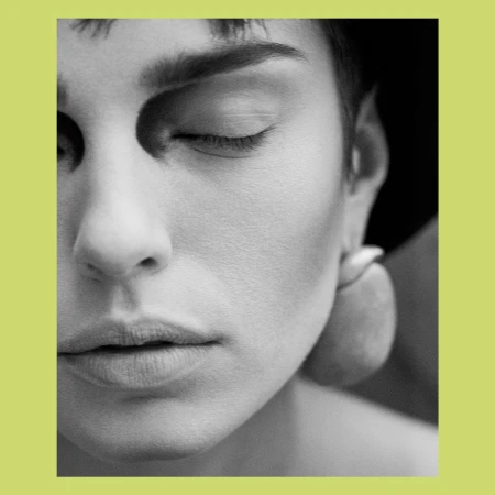 Monochrome portrait of a woman with closed eyes, featuring soft lighting and focus on her facial features and smooth skin texture.