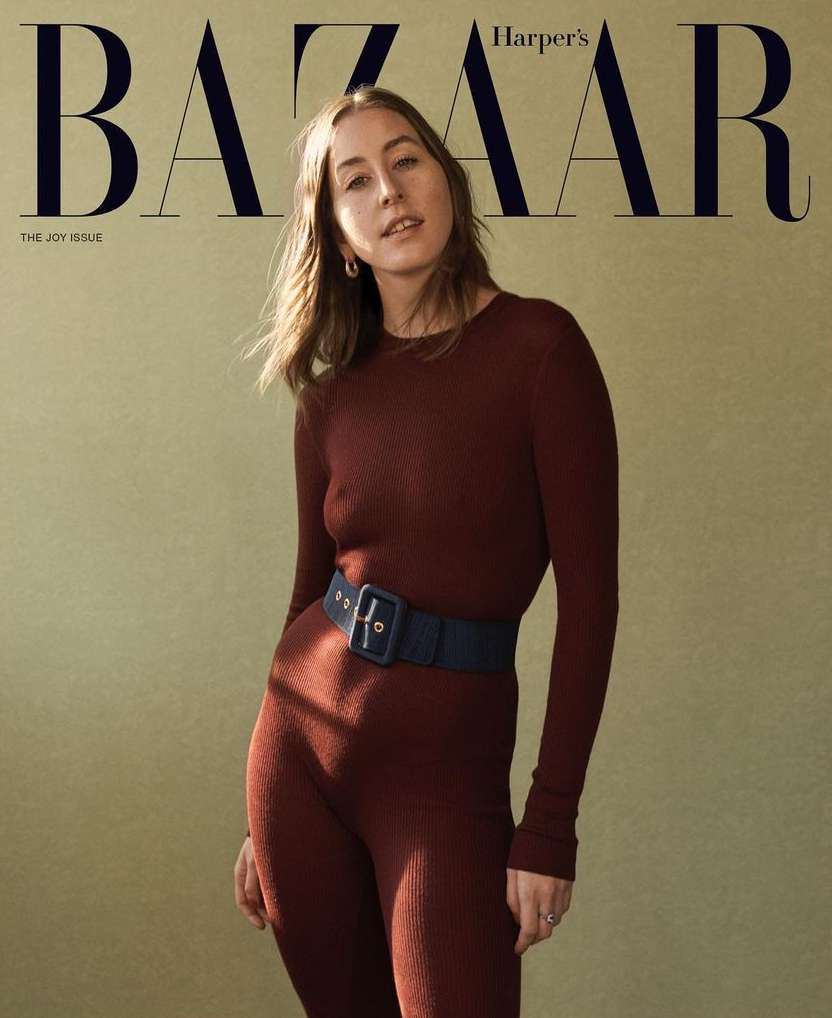 Magazine cover featuring a woman in a burgundy jumpsuit with a navy belt against a neutral background, with 'BAZAAR' prominently displayed.