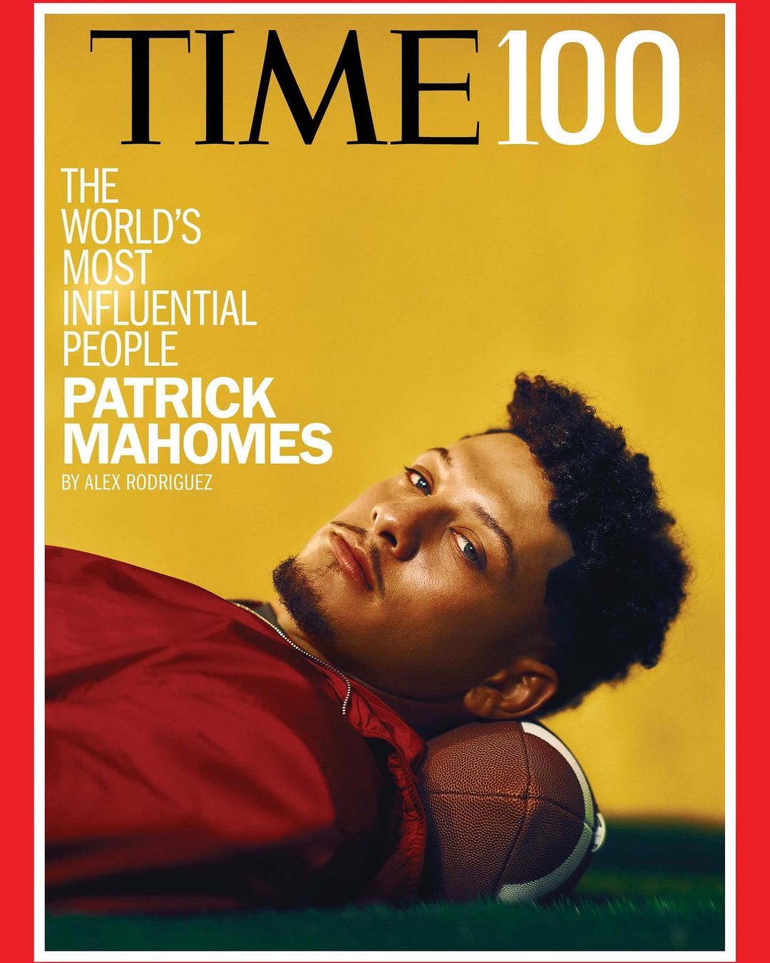 Patrick Mahomes, an adult male, reclines on a football with a focused expression, on the cover of TIME 100 issue.