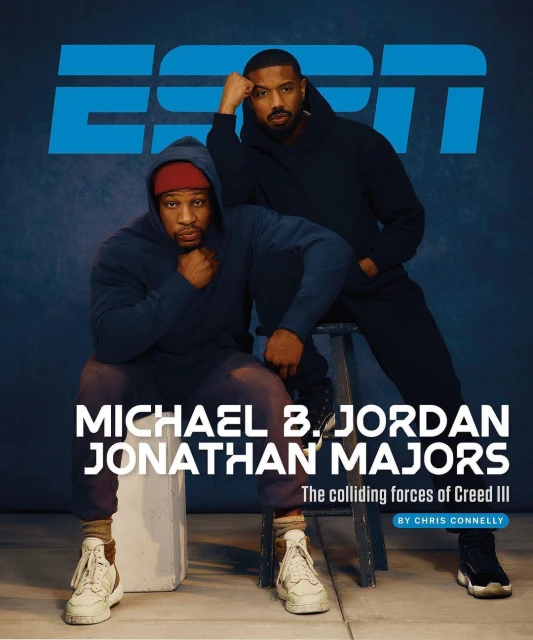 Michael B. Jordan and Jonathan Majors pose indoors in hoodies in a medium shot for an ESPN magazine cover against a blue backdrop.