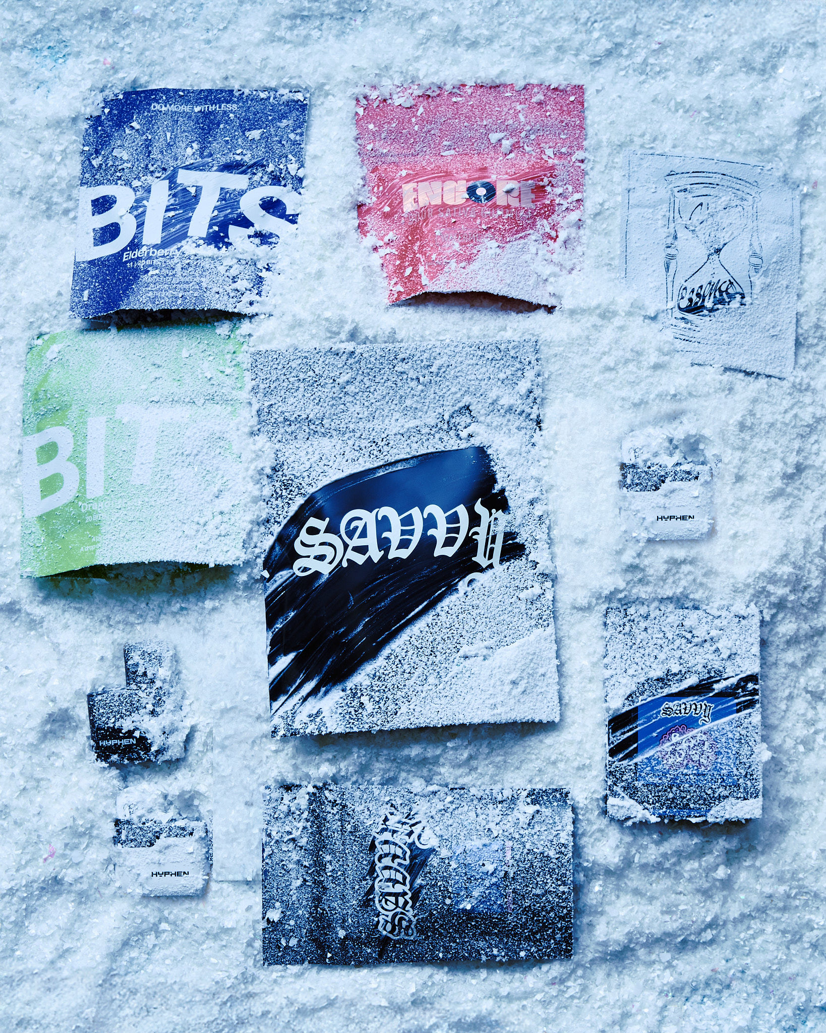 Still life shot of multiple small packages covered in a dusting of white powder, possibly sugar or snow, against a light blue background.