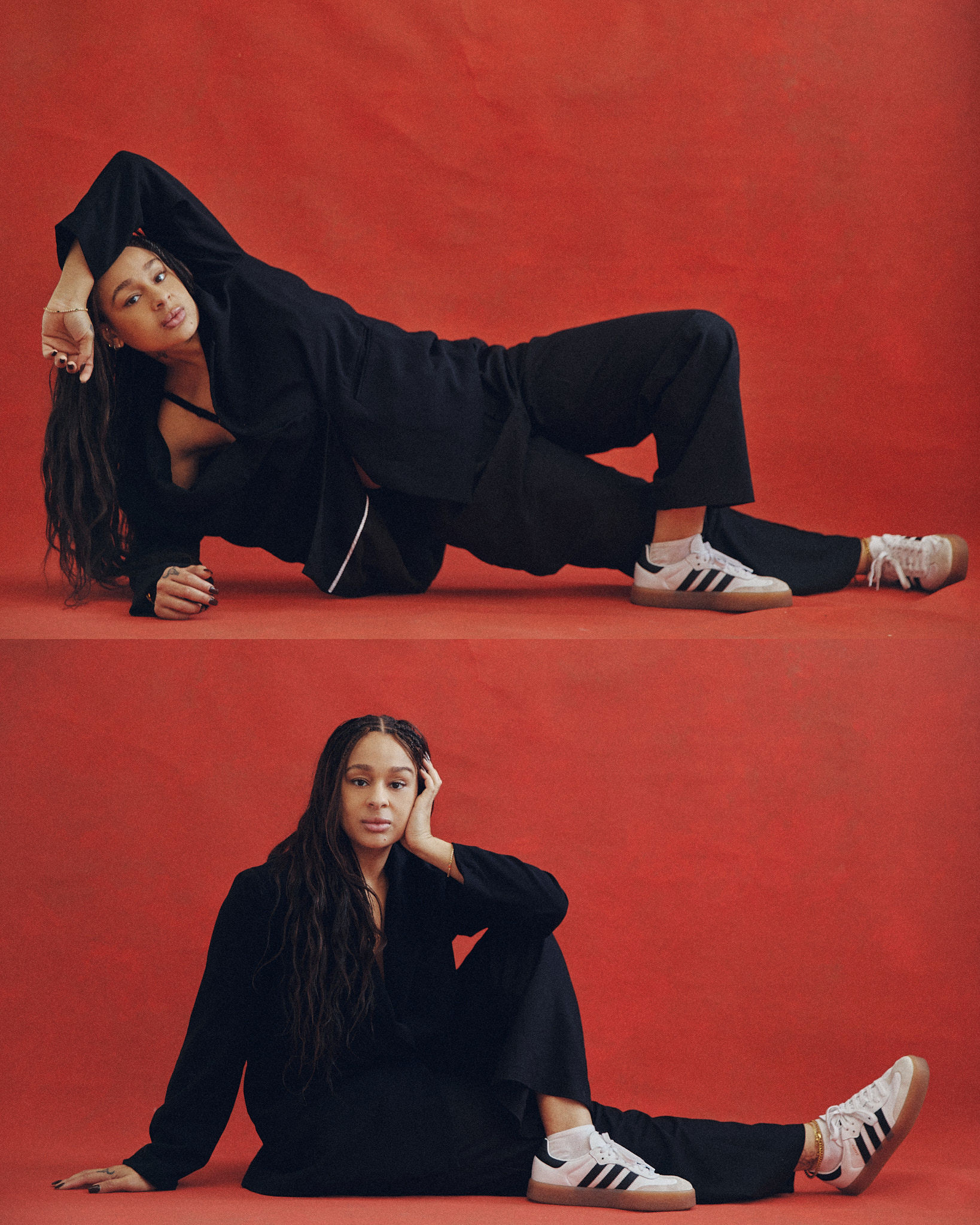 Two women in black suits and Adidas sneakers pose in a photo studio against a red backdrop, capturing a modern and stylish studio portrait.