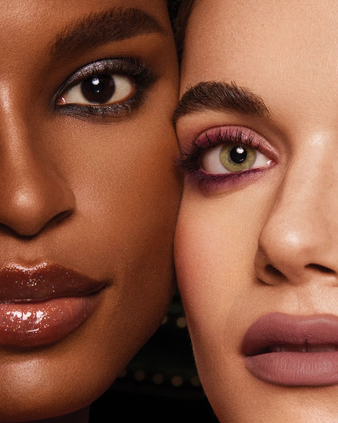 Close-up of two women with unique make-up. One has smoky eyeshadow, while the other has purple eyeshadow and mauve lipstick. Beauty product ad.