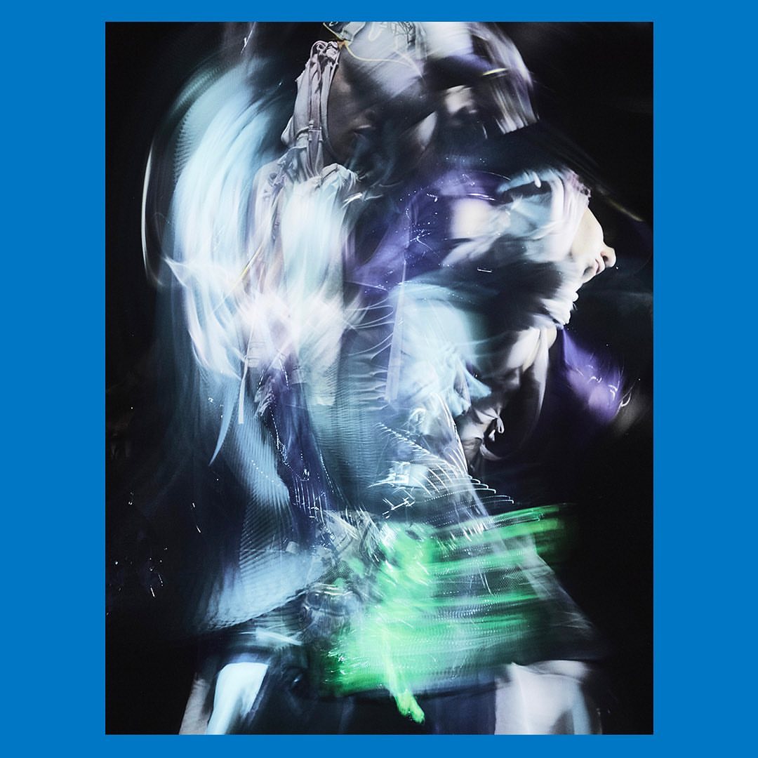 Abstract portrait of a person with blurred, dreamlike qualities, with cool hues of blue, green, and purple against a dark background. 