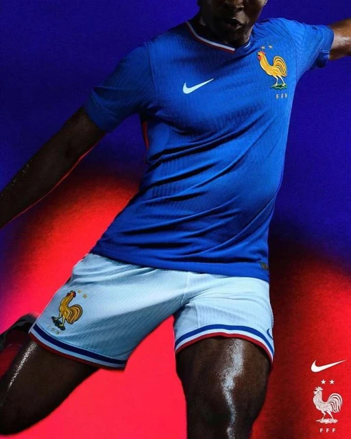 Male soccer player in blue France jersey and white shorts in dynamic pose against a red and blue background. Apparel and sports theme.