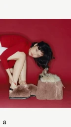 Woman wearing red top and fluffy brown slippers next to a rabbit in a handbag against a red background by Joyce Ng.