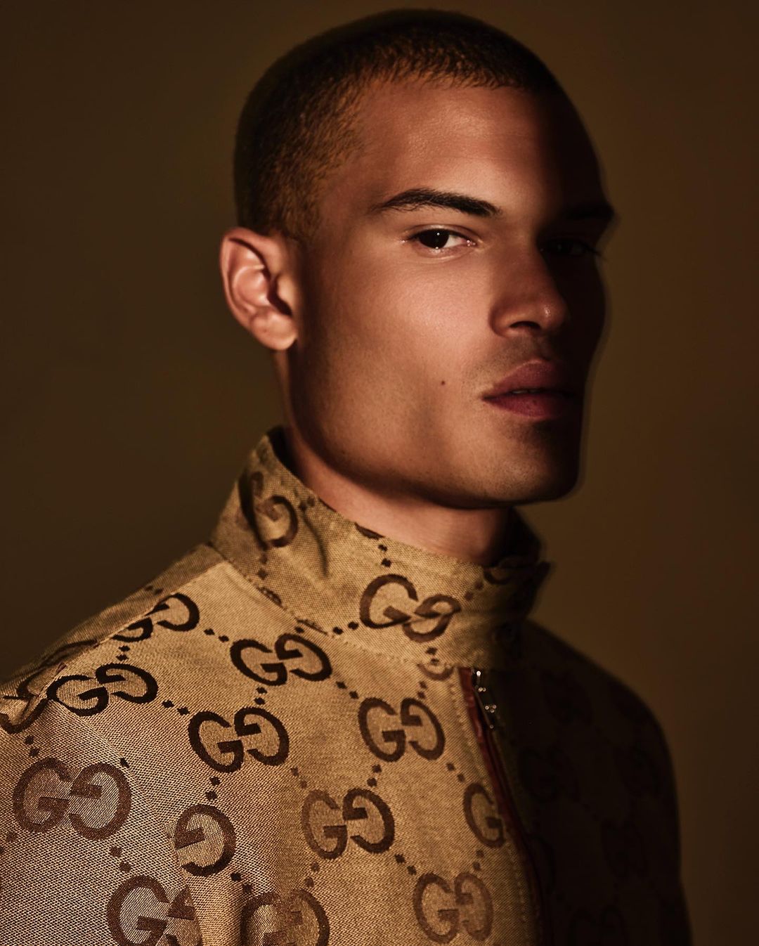 Portrait of a light-skinned adult male in patterned jacket, showcasing fashion and studio photography with neutral backdrop and lighting.