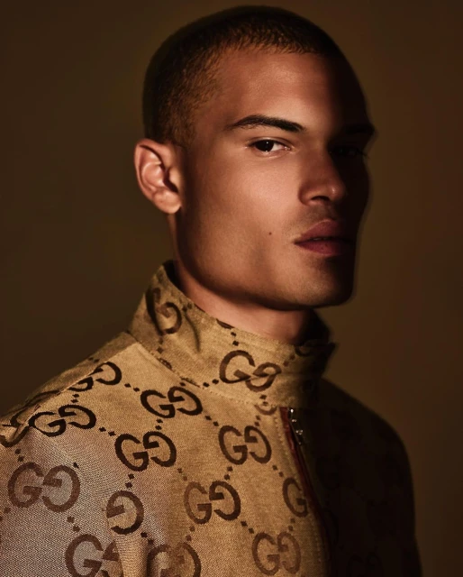 Portrait of a light-skinned adult male in patterned jacket, showcasing fashion and studio photography with neutral backdrop and lighting.