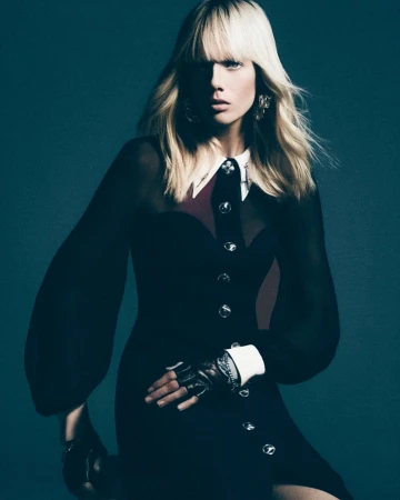 Model with blonde bangs wearing a black dress with white cuffs and collar by photographer Juankr