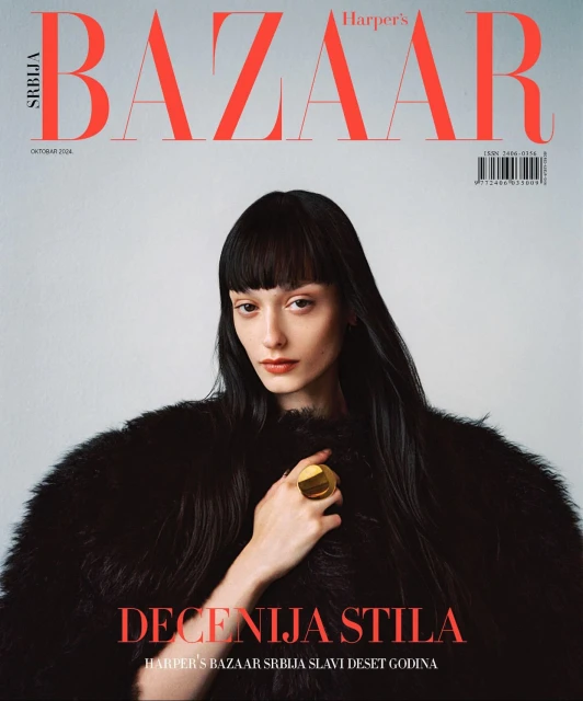 Harper's Bazaar Serbia cover featuring a woman with dark hair wearing a black fur coat and a gold ring, against a light gray backdrop.