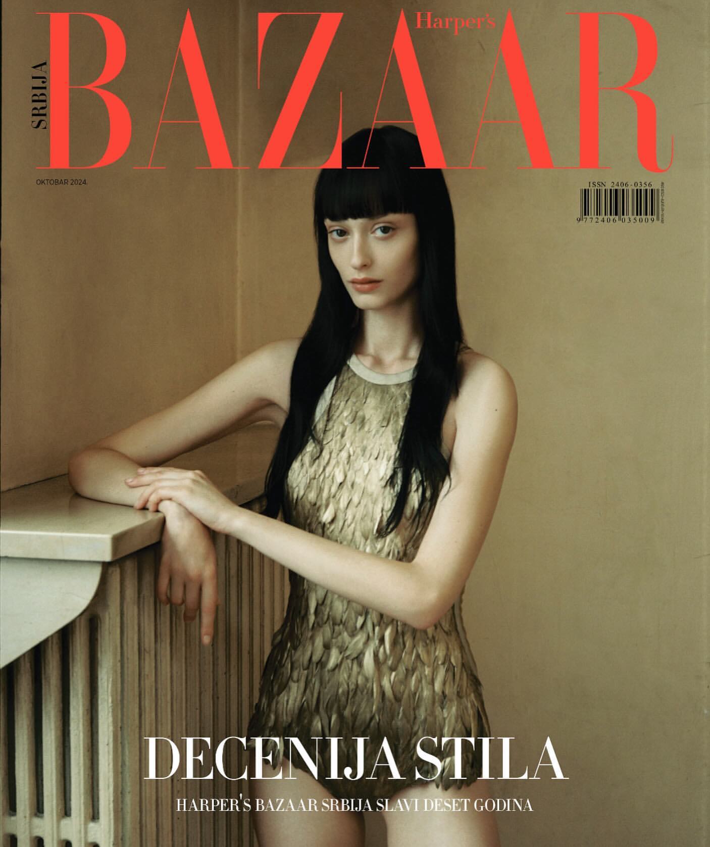 Harper's Bazaar Srbija magazine cover featuring a young woman in a gold dress, posing near a radiator in a neutral-toned room.