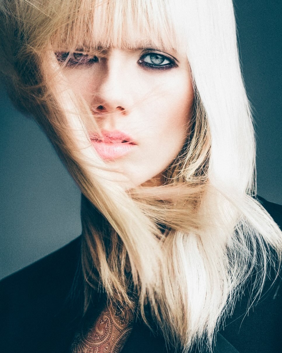 Close-up portrait of a woman with long blonde hair and dark eyeliner by photographer Juankr