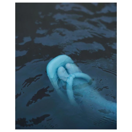 A blue foot and toes float in dark blue water, creating ripples, suggesting an underwater perspective with cool tones and surreal atmosphere.
