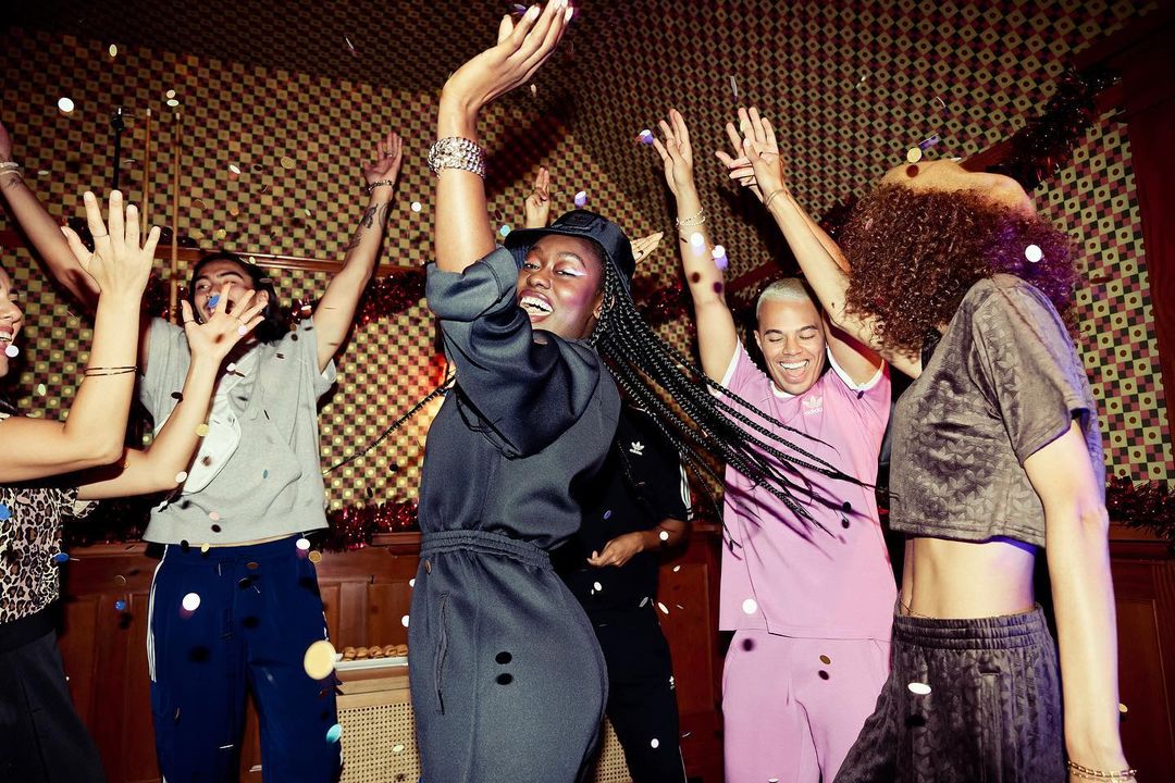 Enthusiastic group of diverse young adults celebrating under falling confetti, capturing a joyful and lively indoor party scene with warm lighting.