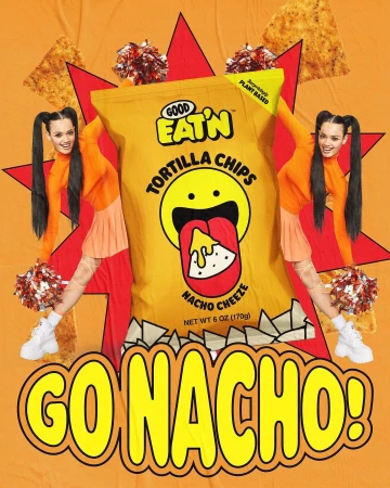 A bag of Good Eat'n Tortilla Chips in Nacho Cheeze flavor is featured with cheerleaders in a vibrant, orange-toned, animated studio setting.