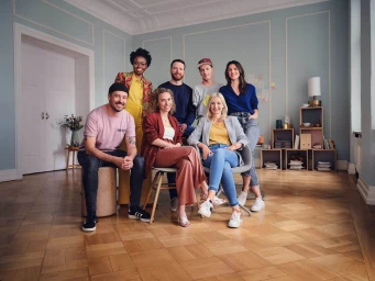 Group of seven diverse professionals posing together in a bright office with herringbone wood flooring by photographer Julia Marie Werner.