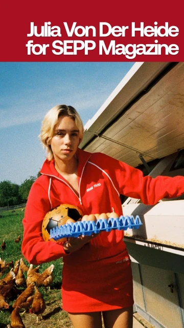 Blonde woman in a red tracksuit outside holding a carton of eggs and a soccer ball with chickens in the background on a farm.