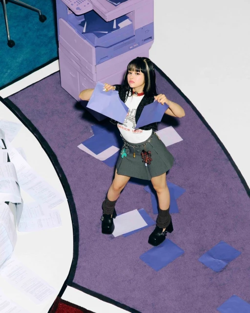 Young woman in miniskirt and leg warmers poses with loose papers near an office copier, cartoon style graphics on white background.