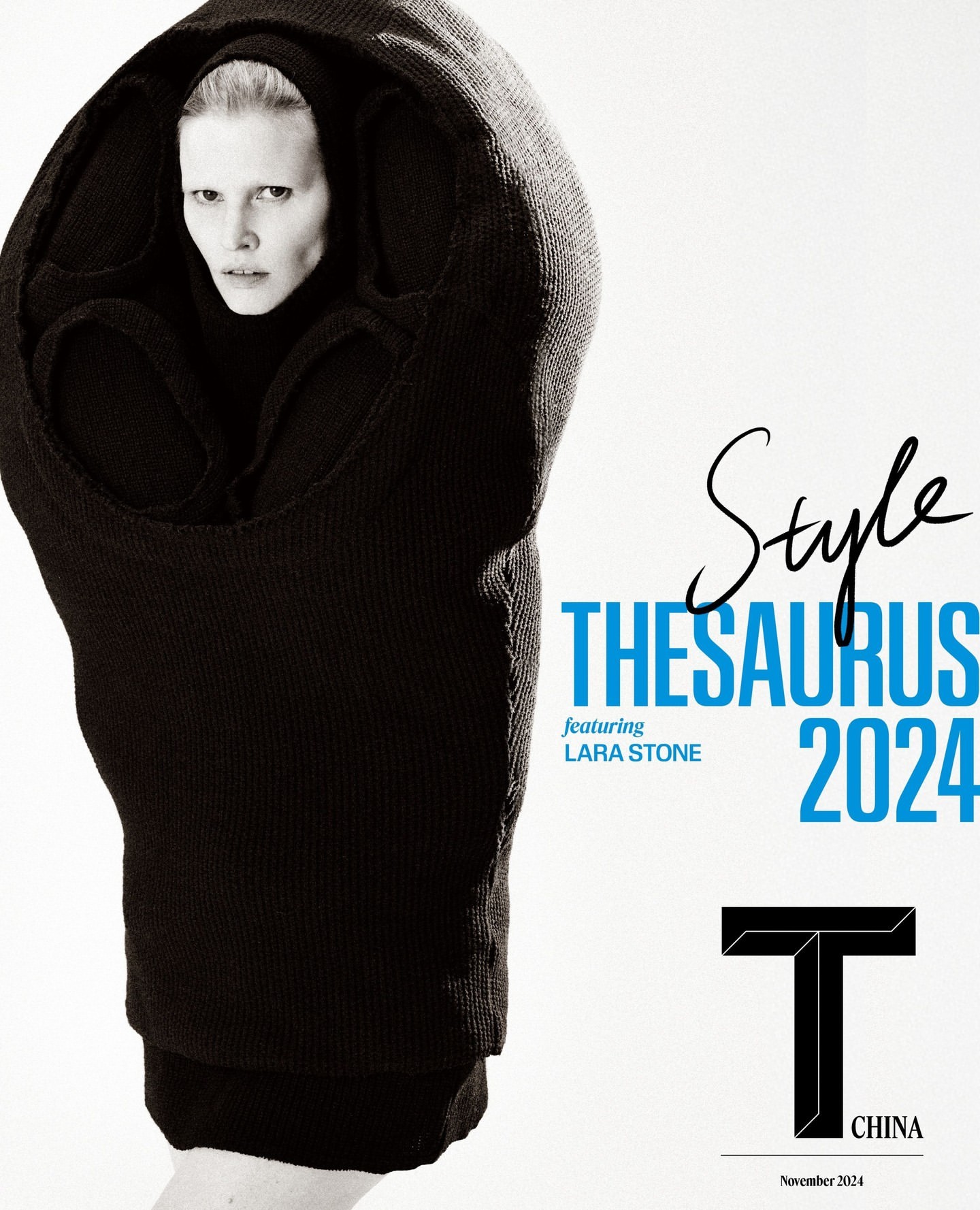 Fashion editorial featuring an adult female model wearing a voluminous, dark-colored hooded garment against a clean, white background.