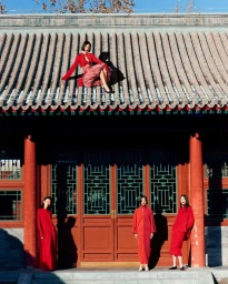 Four models in red attire posing on a traditional Chinese architectural structure by Julian Song