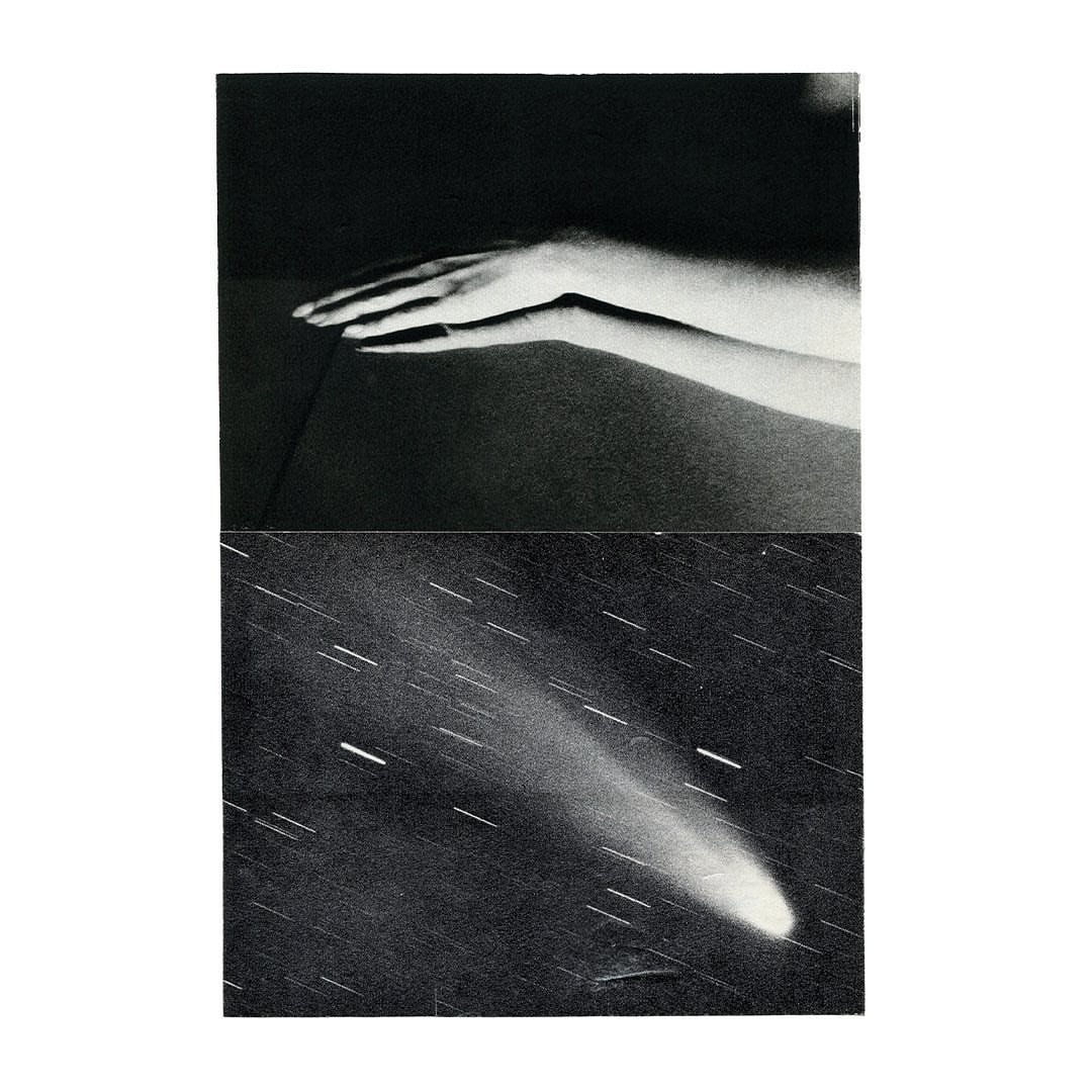 Monochrome image featuring a hand resting on a table above a starry sky with a comet, artful composition, black and white photography.