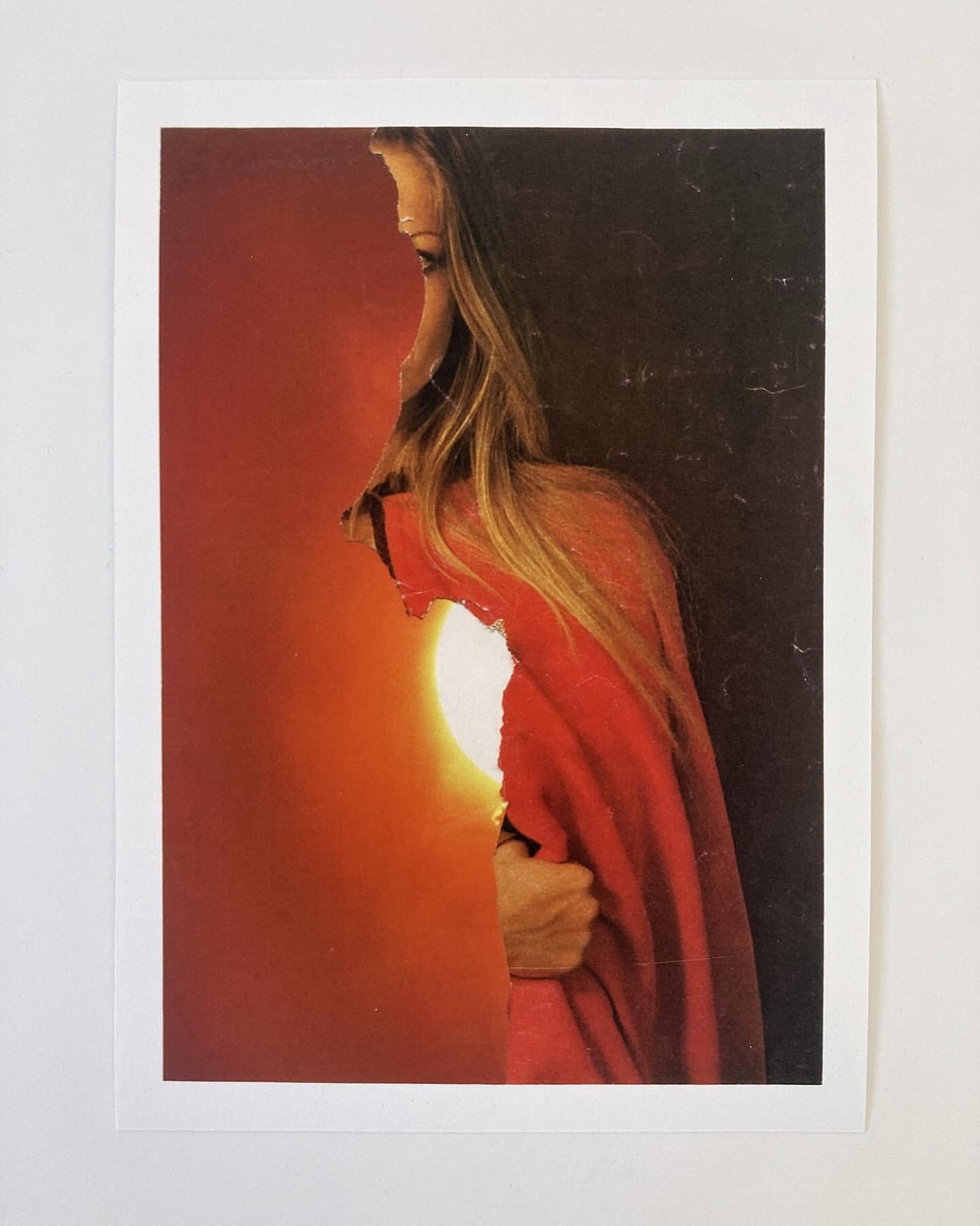 Artistic portrait of a woman with long hair, silhouetted against a red and orange sunset, creating a warm and evocative profile.
