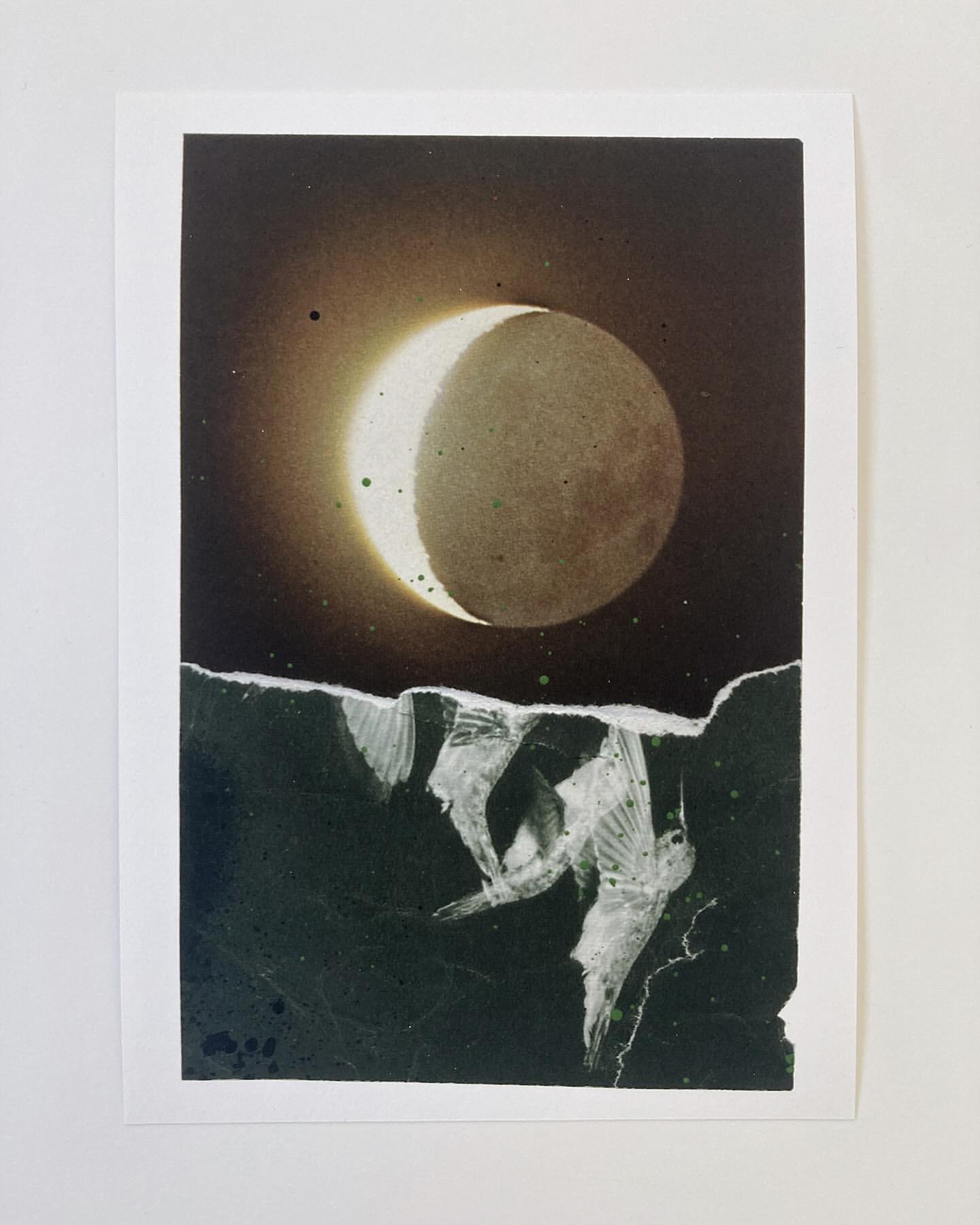 A visually striking image of an eclipsed moon against a dark sky, set above abstract white shapes on a dark background. The print is on white paper.