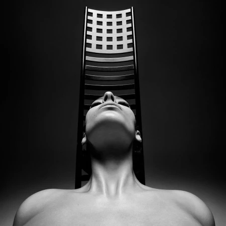 Monochrome portrait of a person looking upward with a tall slatted chair positioned directly behind their head.