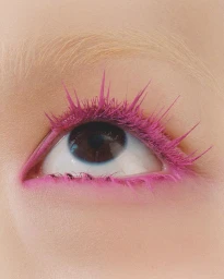 Extreme close-up of a human eye with vibrant pink mascara on long eyelashes and bleached eyebrows captured in Paris by Juliette Allix.
