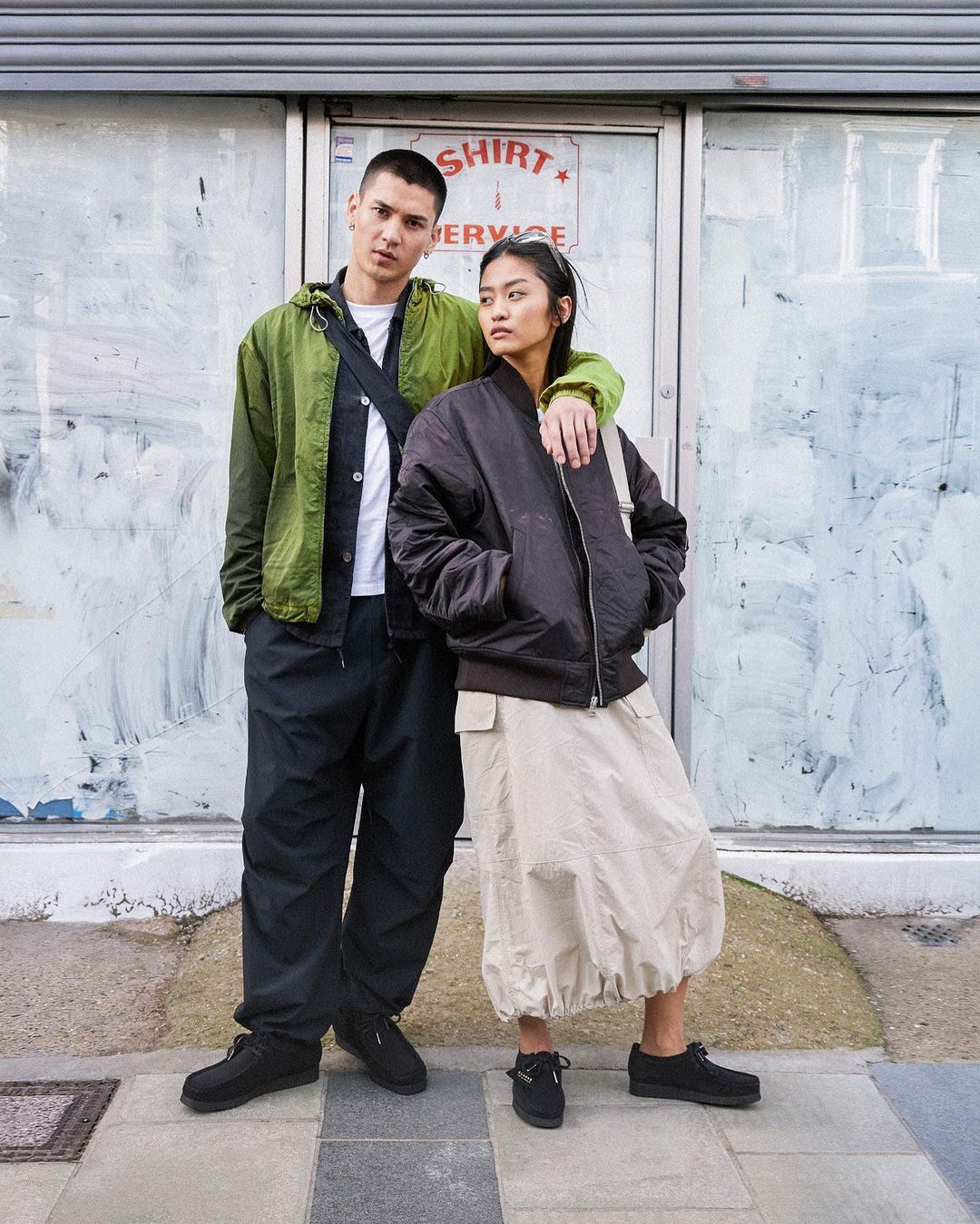 Two models standing on a London street in casual streetwear, photographed by Kaj Jefferies.