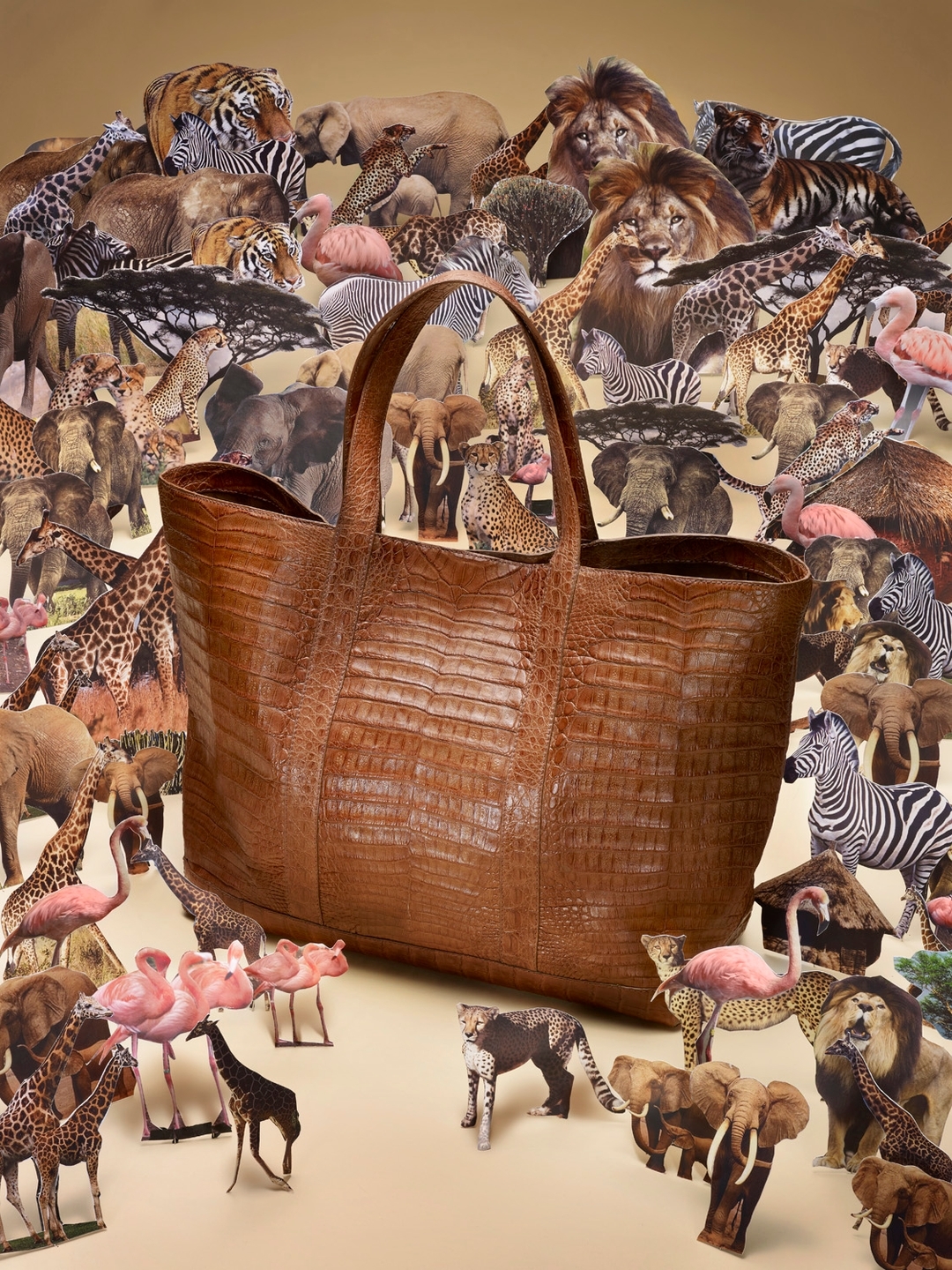 Brown crocodile tote bag surrounded by paper cutouts of wild animals including elephants, lions, tigers, zebras, flamingos, and giraffes.