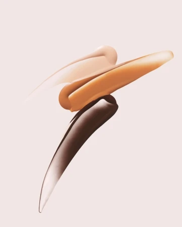 Cosmetic foundation swatches in light, medium, and dark tones displayed against a light pink background in a studio setting.