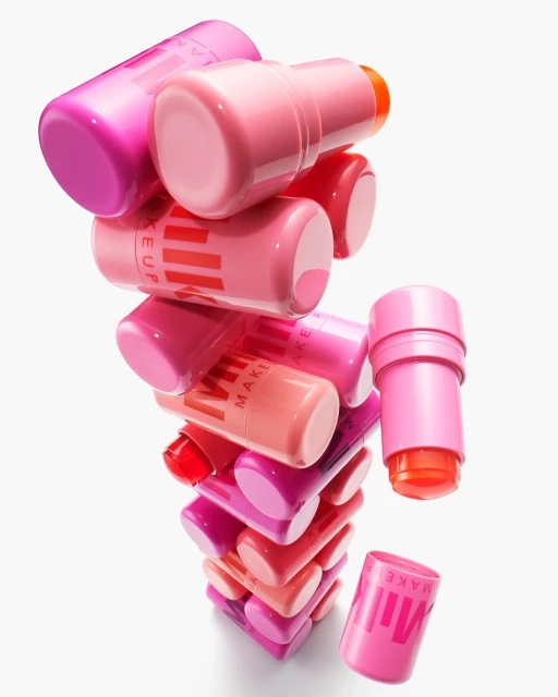 Tower of pink Milk Makeup sticks on a white background, showcasing beauty and cosmetic products with a vibrant color palette for makeup.