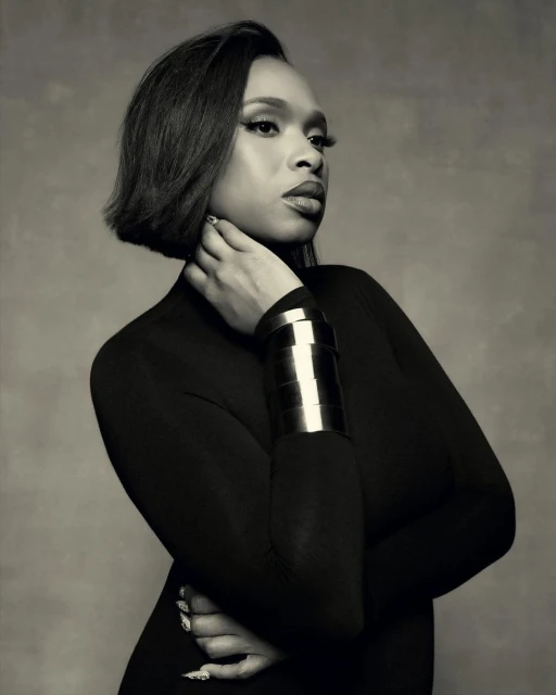 Monochrome portrait of adult woman with bob haircut and metal cuff bracelet against a textured background in a studio setting.