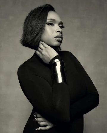 Monochrome portrait of adult woman with bob haircut and metal cuff bracelet against a textured background in a studio setting.
