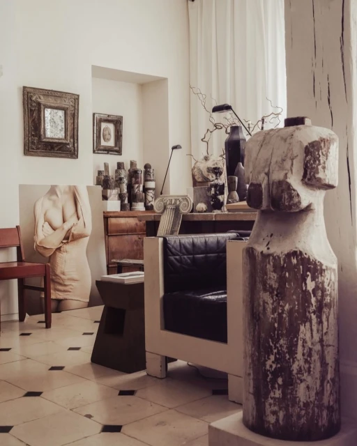 Art studio interior with classical busts, sculptures, decorative vases, art objects, and modern chair. Interior and architecture photography.