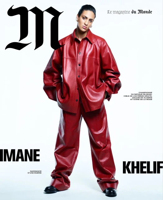 Imane Khelif posing on a Le Monde magazine cover, wearing a red leather suit with black shoes against a white background.