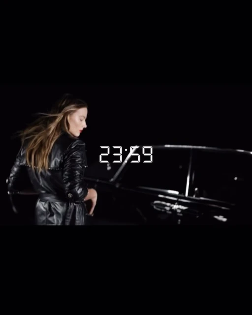 Stylish woman in a black leather trench coat near a limousine at night, creating a dramatic and fashionable street scene.