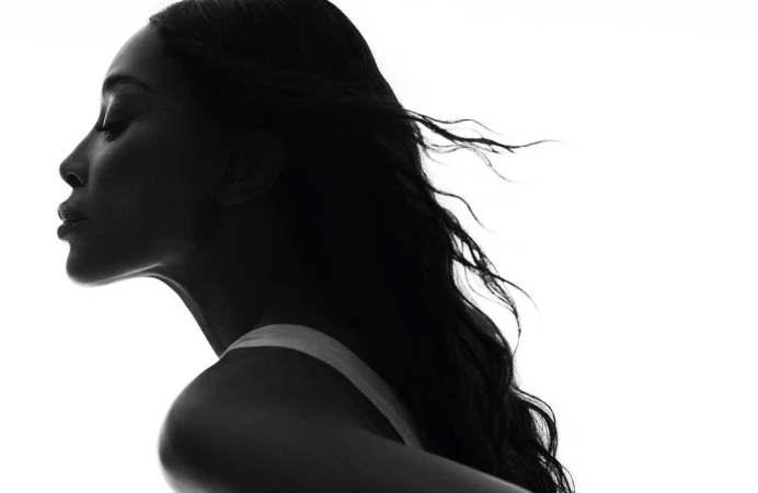 Striking black and white portrait of a woman in profile, featuring elegant, flowing hair and a minimalist fashion aesthetic.