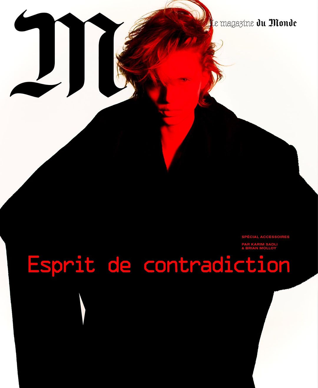 Fashion magazine cover featuring a person with red hair in a dark coat against a white background with red and black text.