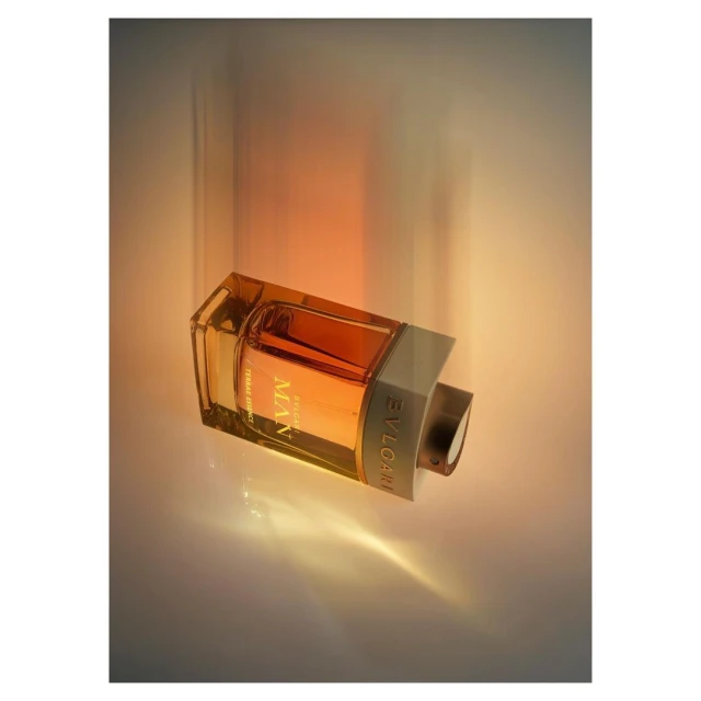 BVLGARI MAN Terrae Essence amber fragrance: transparent glass bottle with amber liquid at a diagonal against a white surface.