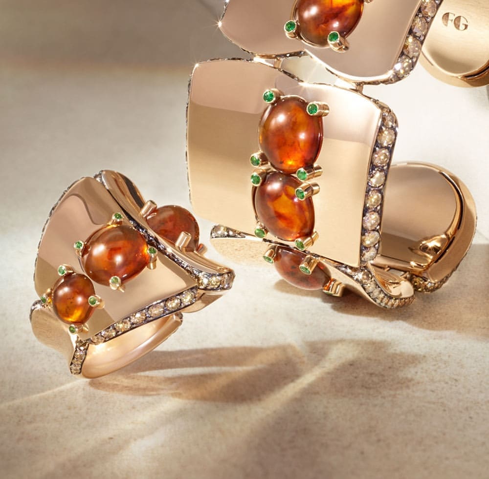Close-up of a gold ring and bracelet featuring amber stones and diamond accents, set against a neutral backdrop. Jewelry still life.