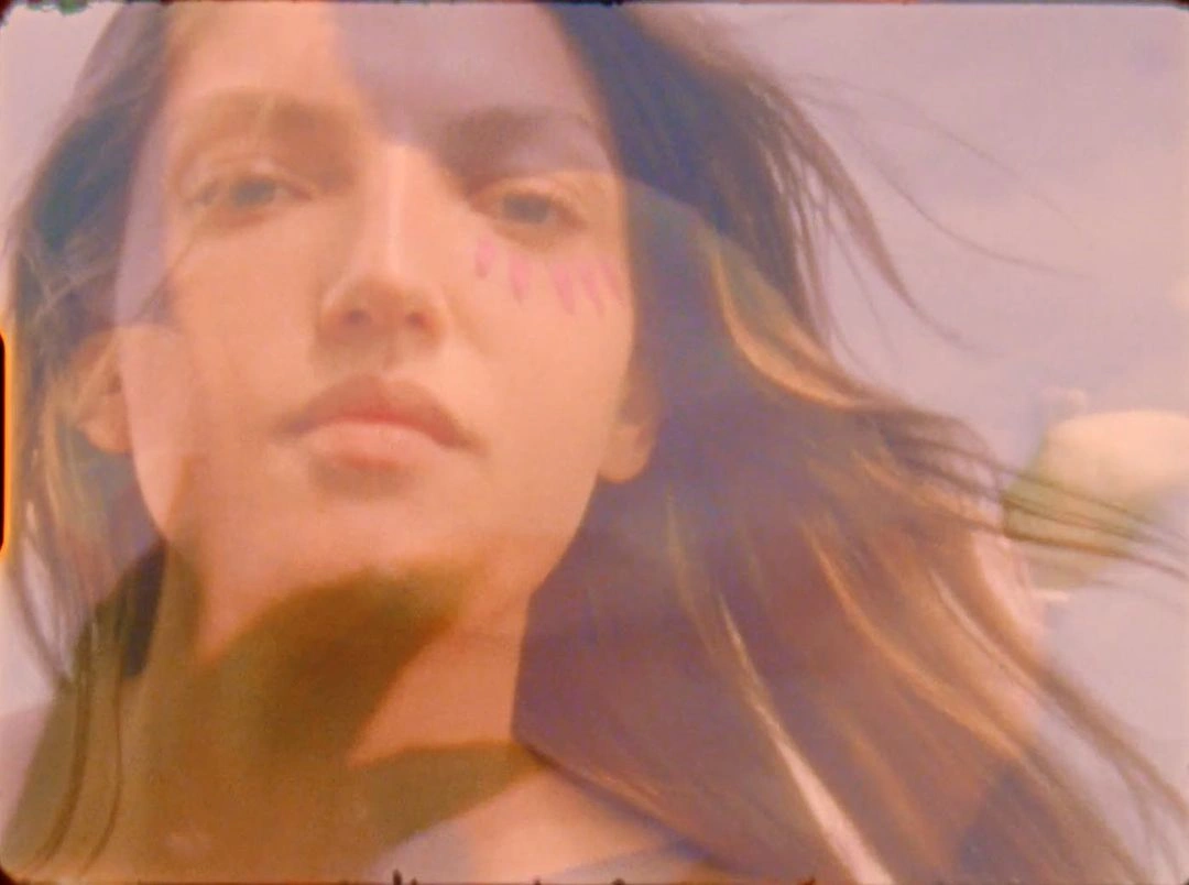 Close-up portrait of a woman with long hair blowing in the wind, featuring double exposure photography by Karin Berndl.