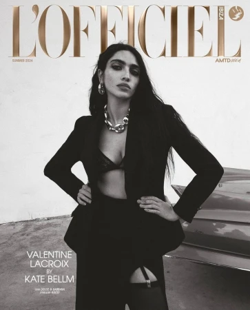 L'Officiel Ibiza Summer 2024 cover featuring a woman in a black blazer, bralette, and stockings, posing with hands on hips near a car.