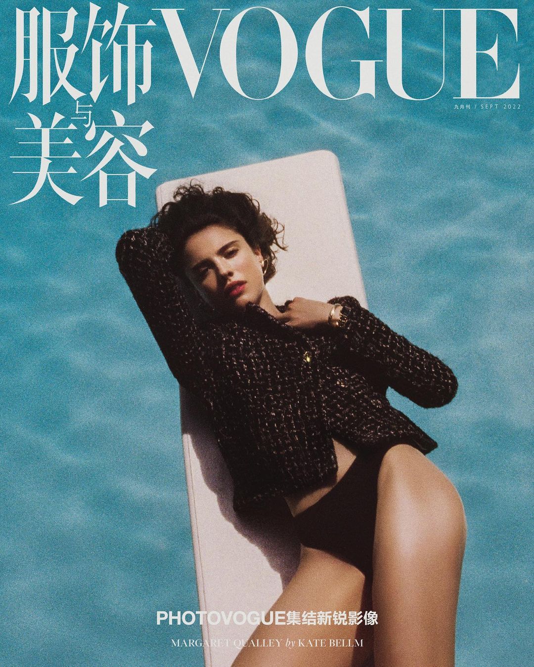 Vogue cover featuring a woman in a black jacket and bikini bottoms laying on a white platform in a pool with bright blue water.